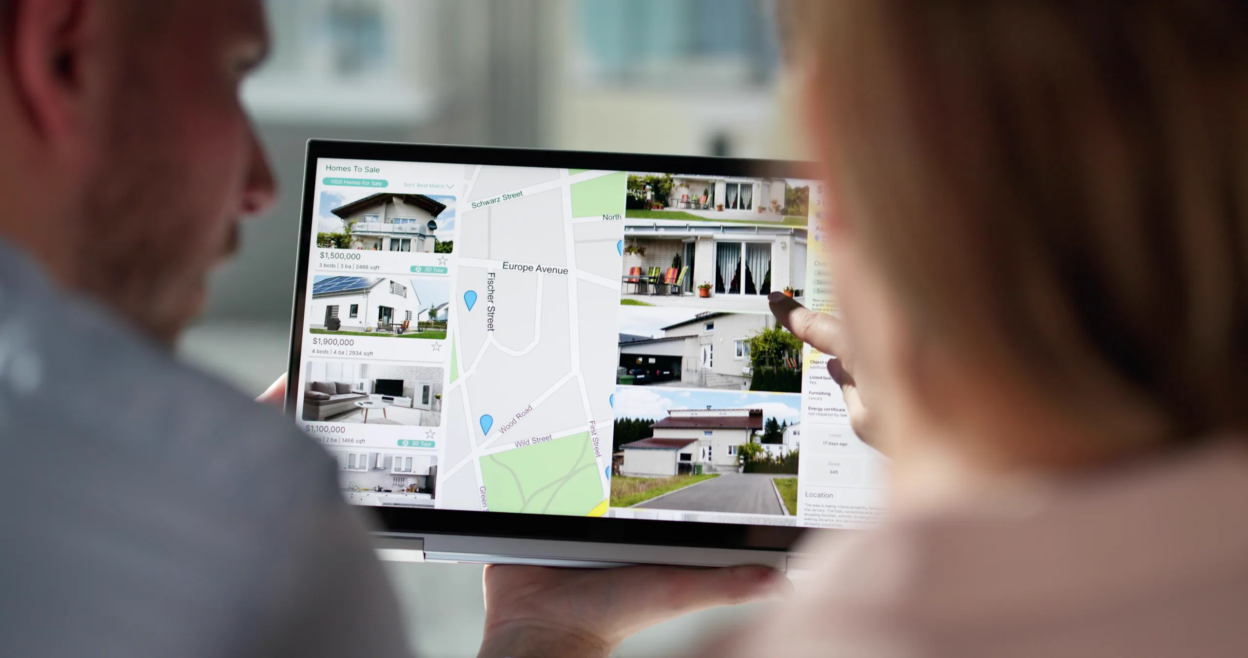Couple looking at homes for sale and a map on a screen